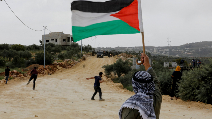 A demonstrator holds a Palestinian flag during clashes with Israeli forces at a protest against Israeli settlements, Nablus, in the Israeli-occupied West Bank, Palestine, April 10, 2023. (Reuters Photo)